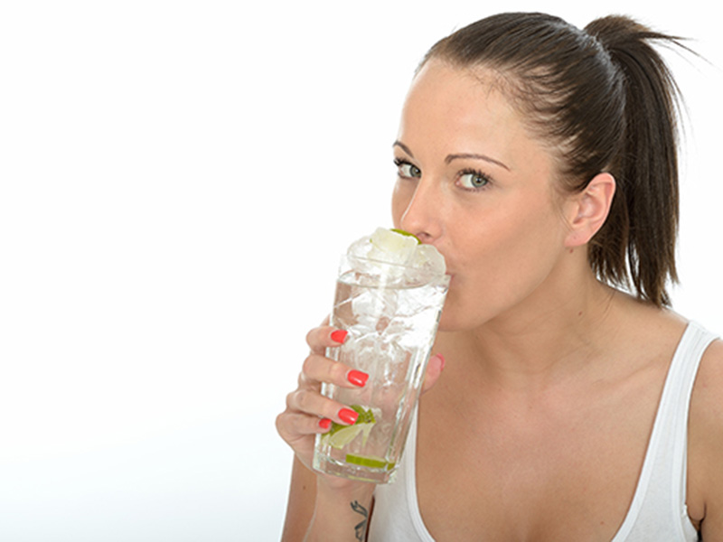 young women drinking glass of ice water