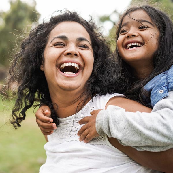 Mother playing with child after getting general dental care in Florence, KY & Tri-State area.